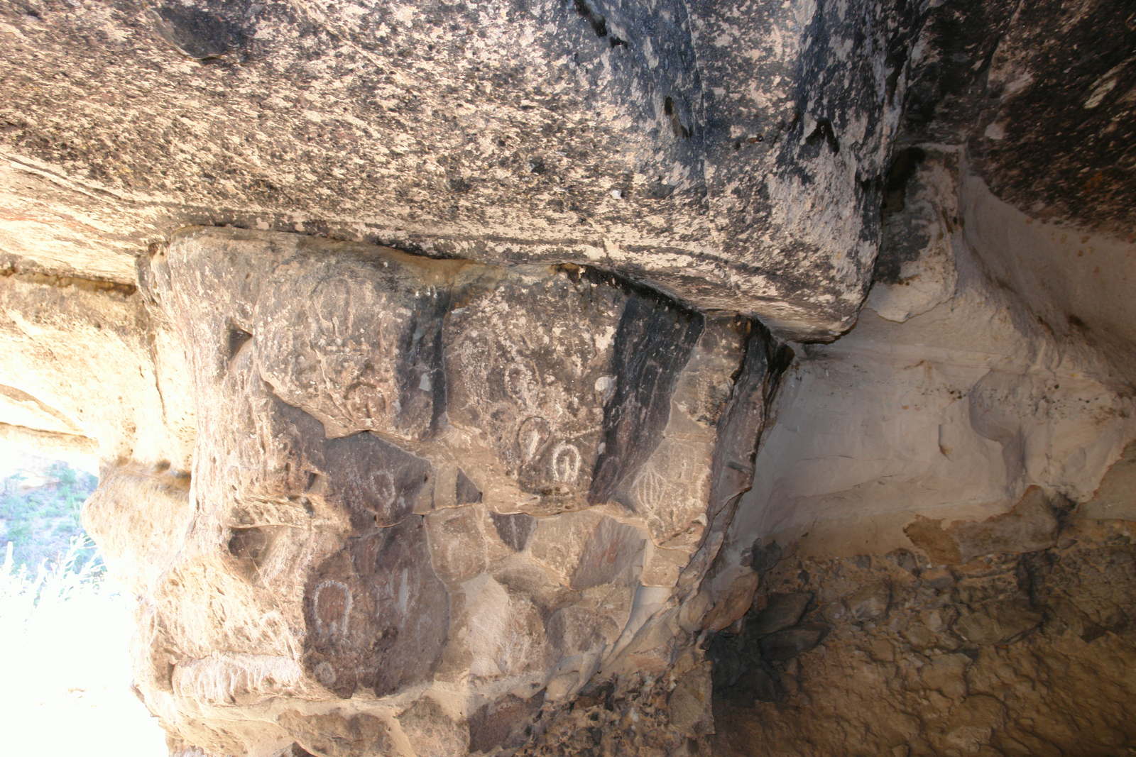 Vulvaform petroglyphs carved into the soft tuff walls.