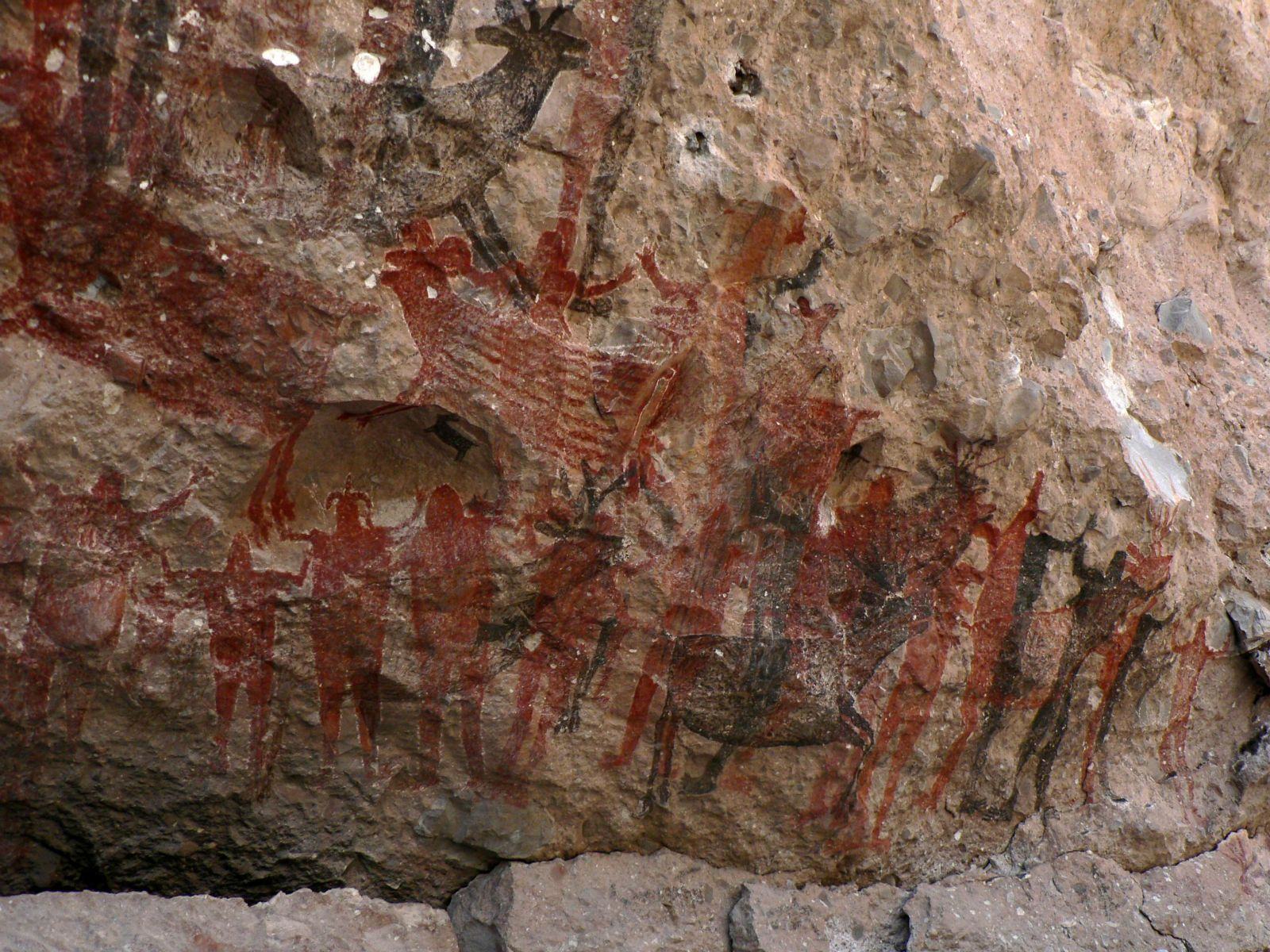 This image shows a portion of the famous South Gallery of Cueva Pintada.  Note the monos (human figures) at the bottom of the gallery.